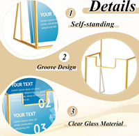 Présentoir minimaliste en fil doré avec base ouverte pour brochures, cartes et petites impressions d'art sur comptoir
