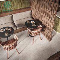 Ensemble de mobilier de café Wabi-Sibi : table ronde en pierre frittée, chaise en rotin, banquette rembourrée