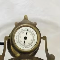 Horloge/skellétoir de style français antique en laiton poli, mouvement à dôme ovale, calendrier et baromètre