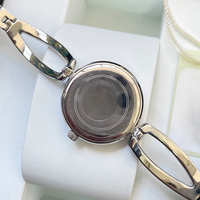 Montre pour femme de luxe simple à quartz, bracelet en strass en forme de fer à cheval creux, cadran en nacre blanche, lunette entièrement sertie de cristaux