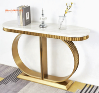 Table console moderne de luxe avec plateau en marbre noir et piètement en acier inoxydable doré, table console de luxe en métal doré pour hall d'hôtel