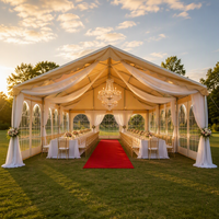 Tente de réception de mariage de luxe avec murs en verre arqués, draperies de plafond, lustre en cristal, chapiteau de réception de mariage en plein air sur pelouse