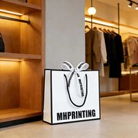 Sac en papier écologique blanc à cadre noir avec logo personnalisé, recyclable pour les sacs cadeaux d'exposition, les bijoux et les accessoires