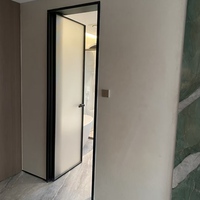 Porte de salle de bain minimaliste standard à charnières avec cadre en alliage titane-magnésium et panneaux en verre dépoli pour toilettes intérieures d'hôtel