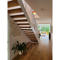 Escalier sur mesure à double poutre avec balustrade en verre pour bâtiment résidentiel