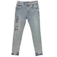Jean slim homme coupe skinny délavé vintage effet vieilli avec éclaboussures de peinture et imprimé graffiti, style streetwear hip-hop