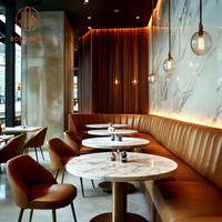 Ensemble de meubles modernes pour café, restaurant, tables rondes en marbre avec pieds cylindriques en métal, chaises et canapés en cuir marron
