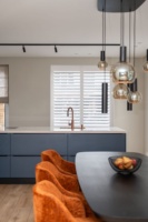 Ensemble d'armoires de cuisine sur mesure en finition bleu foncé avec évier en cuivre, plaque de cuisson à induction et four encastré