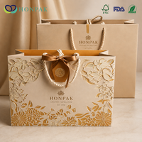 Sac cadeau en papier de luxe, design floral ajouré, poignée en corde, logo personnalisé, emballage haut de gamme pour boutique HONPAK