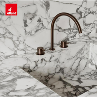 Cuisine Alland moderne et minimaliste, avec panneaux plats mats couleur crème personnalisés, îlot et plan de travail en marbre blanc.