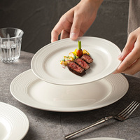 Assiette de table ronde en céramique blanche personnalisable avec logo, idéale pour hôtels et restaurants, compatible micro-ondes et lave-vaisselle
