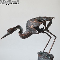 Statue d'oiseau en métal d'heron d'apparence abstraite debout sur une bûche, décoration en métal de jardin