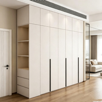 Armoire sur mesure minimaliste moderne du sol au plafond, blanche, intégrée pour chambre à coucher, avec éclairage LED, étagères ouvertes, tiroirs et poignées longues noires
