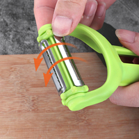 Multifunctionele handmatige plastic aardappel- en groenteschiller met roestvrijstalen mes, rood/groen, huishoudelijk gebruik.