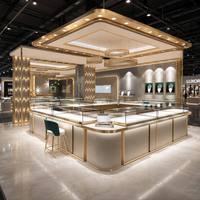 Solution complète de design d'intérieur pour bijouterie de luxe beige et or, avec comptoir d'exposition incurvé en verre sur mesure pour îlot de bijoux