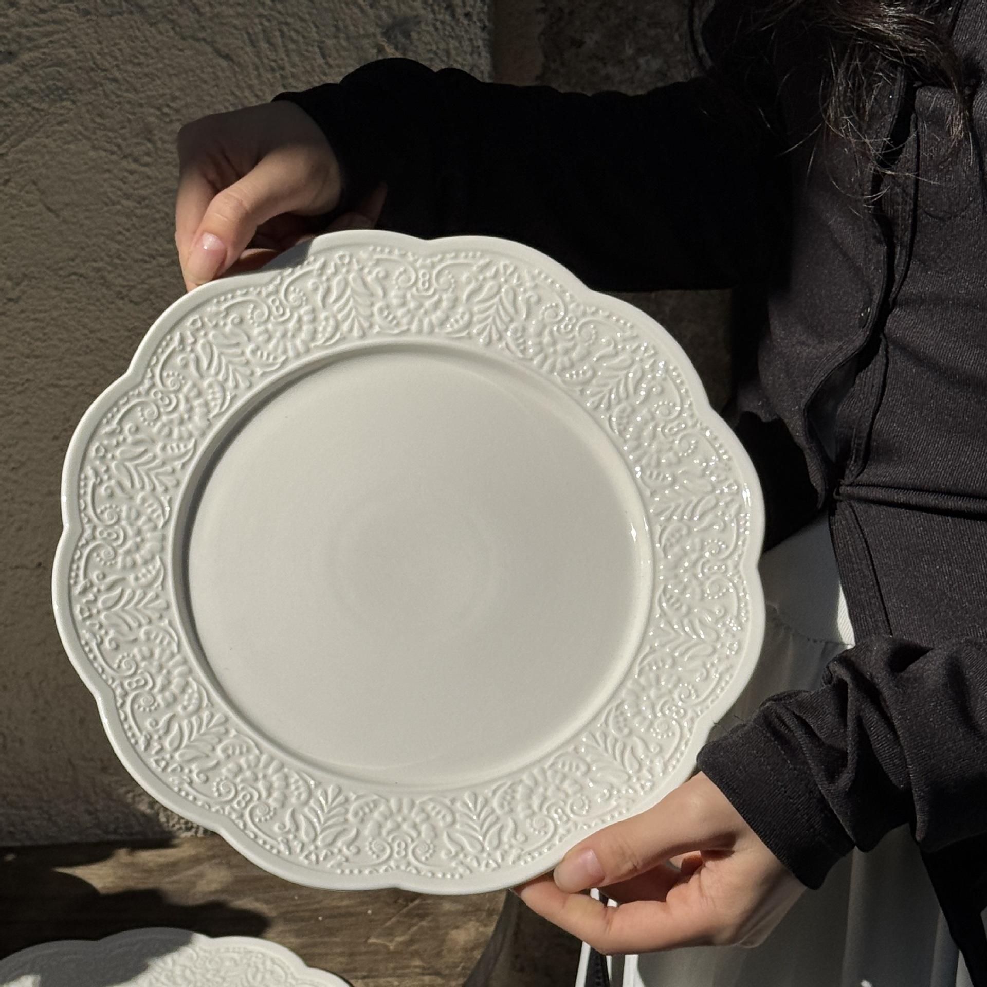 Plateau 25 cm avec motif en relief de pétales de fleurs blanches et feuilles.