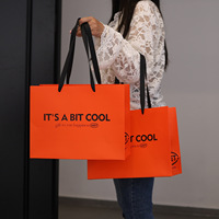 Sac fourre-tout en papier orange uni personnalisé en usine avec motif de lettres imprimé pour la promotion de la marque et l'emballage de cadeaux