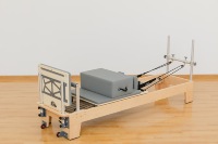 Ce Reformer de Pilates Commercial utilise du bois d'érable importé et des montants en aluminium, il possède 6 ressorts et 7 réglages de barre.