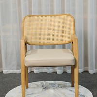 Chaise de salle à manger à bras angulaires avec dossier en rotin suspendu et assise rembourrée sur structure à grain clair pour salle de bain et atelier