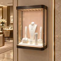 Vitrine murale pour bijoux sur mesure, vitrine en verre avec coins arrondis, cadre en métal noir, panneau arrière rose, éclairage LED
