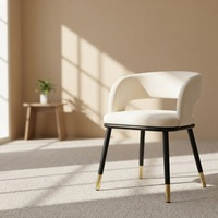 Chaise de salle à manger moderne en velours blanc cassé, dossier souple en U, pieds avec embouts dorés, structure en métal noir, idéale pour la maison, le bureau ou les espaces publics.