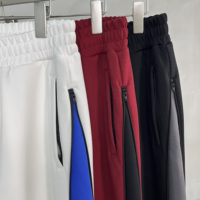 Pantalon de jogging large à rayures avec poches zippées YKK, fente à l'ourlet, panneaux contrastants et patchwork bicolore sur les côtés