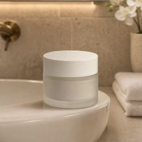Pot de crème cosmétique minimaliste, surface givrée lisse, couvercle à vis blanc, conteneur à large ouverture