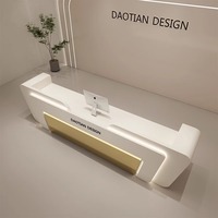 Bureau de réception professionnel moderne de luxe haut de gamme avec surface incurvée en or blanc et éclairage LED personnalisé pour hall d'immeuble commercial