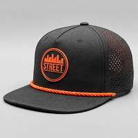 Casquette Snapback Noire à Bord Plat avec Patch en Caoutchouc Orange et Corde Tressée Perforée sur le Côté pour Hommes – Idéale pour le Quotidien Urbain