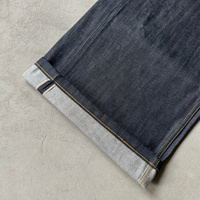 Jeans en denim brut à poche incurvée et boucle arrière, braguette boutonnée, jambe large, denim selvedge, double poche arrière, boucles croisées, jeans baggy