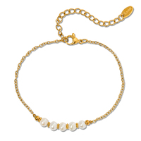 Bracelet chaîne gourmette en acier doré architectural avec quatre perles baroques, maillons épais connectés à un câble fin, fermoir réglable pour femme