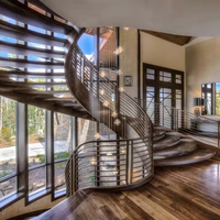Escalier incurvé en fer forgé avec escalier intérieur en marbre pour villa moderne avec garde-corps en verre caractéristique architecturale en spirale