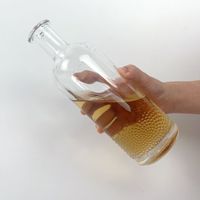 Bouteille d'alcool ronde en verre à bouche plate avec gaufrage gravé