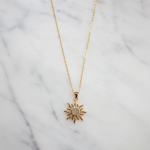 Colgante de sol dorado radiante con centro de cristal, que simboliza energía y positividad, perfecto para el uso diario o para regalar. - Product Image 1