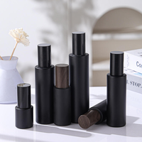 Ensemble d'emballages cosmétiques en verre noir mat en gros avec couvercle en bois, flacon pompe, pot à crème, flacon compte-gouttes pour sérum pour les soins de la peau