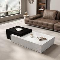 Table basse contemporaine noire et blanche rectangulaire avec plateau en pierre et rangement caché pour ensemble de canapés.
