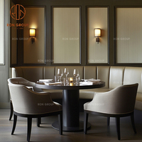 Ensemble de mobilier de café-restaurant : canapé banquette incurvé en velours beige, tables rondes en bois et chaises à assise en tissu pour café