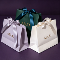 Sac en papier de luxe personnalisé avec logo pour bijoux, sac en papier blanc de luxe avec poignée en ruban pour emballage de pantalons, chapeaux et parfums