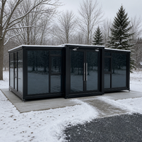 Maison conteneur pliable extensible avec cadre noir et verre teinté, dotée de doubles portes, idéale pour le glamping hivernal et l'hébergement