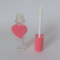 Tubo cilíndrico para brillo labial con tapa en espiral, etiqueta en forma de corazón rosa, material plástico