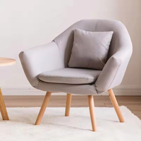 Fauteuil de salon confortable avec dossier et pieds en bois orange, style nordique moderne
