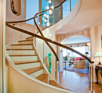 Transformez votre espace de vie avec une escalier en arc moderne doté d'entretoises ouvertes et de garde-corps en verre pour une luminosité naturelle maximale