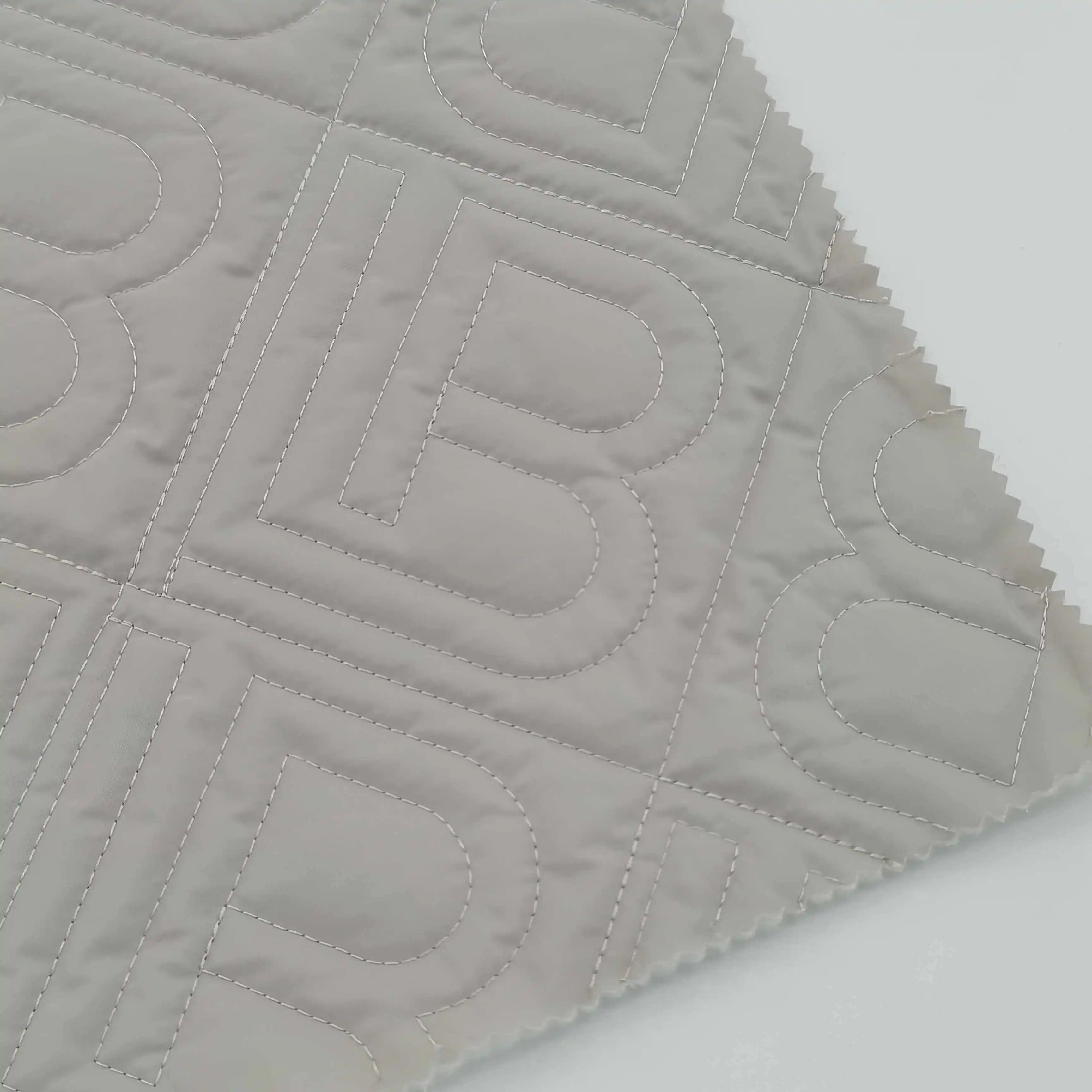 Tissu à mémoire imitée imperméable à l'eau 100% polyester de couleur gris Offre Spéciale avec motif de mot B de couette pour veste de trench longue pour femme