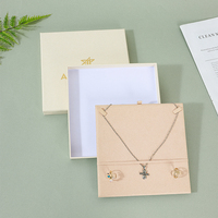 Boîte d'emballage de bijoux A1 mate crème avec plateau multi-compartiments, positionnement pour pendentifs et bagues, et impression personnalisée sur le couvercle