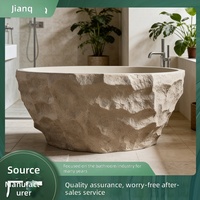 Baignoire autoportante artistique de style Wabi-sabi moderne et minimaliste, en pierre naturelle, avec détails en galets, capacité pour deux personnes