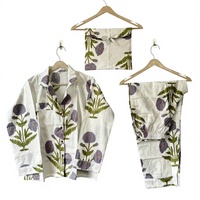 Ensemble de vêtements de détente élégants avec motifs de fleurs violettes et de feuilles vertes sur fond blanc, créant un design botanique frais.