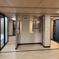 Maison conteneur durable et extensible de 20 pieds avec toit à pignon, cadre noir anthracite, fenêtres en treillis, terrasse isolée pour lodge rural