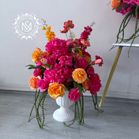 Centre de table floral artificiel éclatant, fleurs rose vif et orange, idéal pour la décoration de tables de mariage et les événements de banquet.