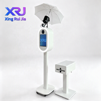 Xingruijia XRJ-cmp Photomaton ovale en métal à impression instantanée, écran tactile 14 pouces, appareil photo, impression en libre-service, ventilateurs de refroidissement RGB, détachable