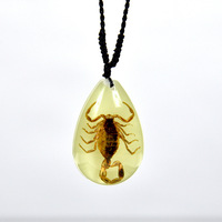 Collier en ambre avec scorpion réel en résine luminescente et graphismes brodés